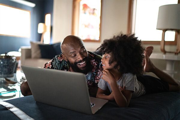 Vater und Kind schauen Netflix am Laptop