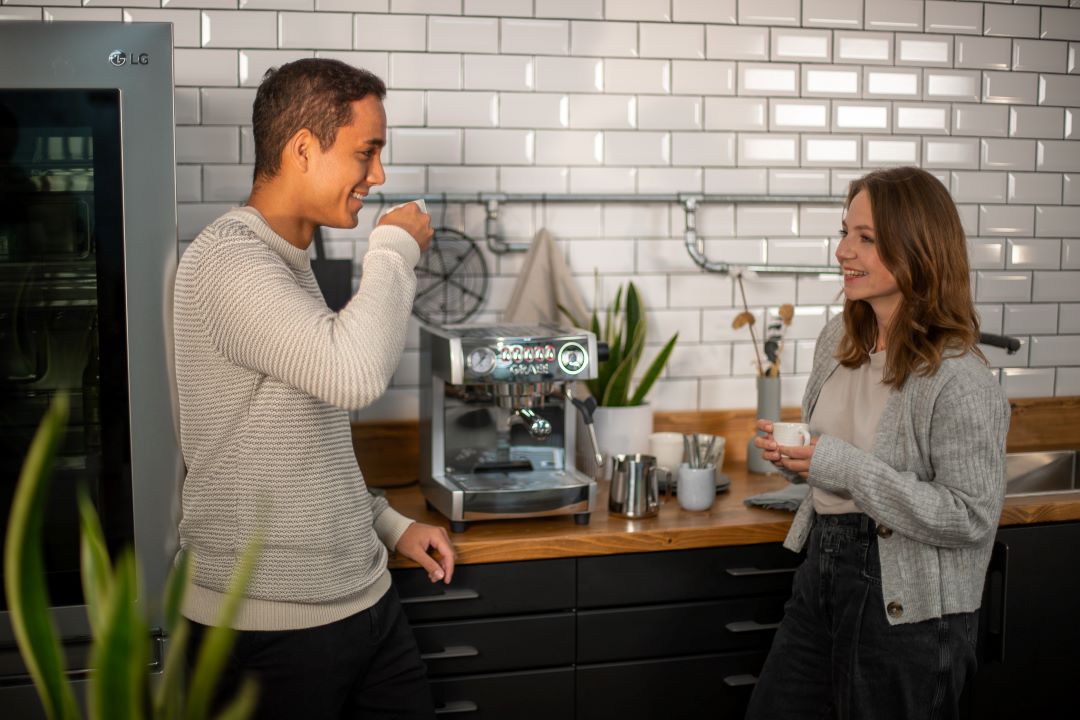 Mann und Frau trinken Kaffee zubereitet mit refurbed Kaffeemaschine