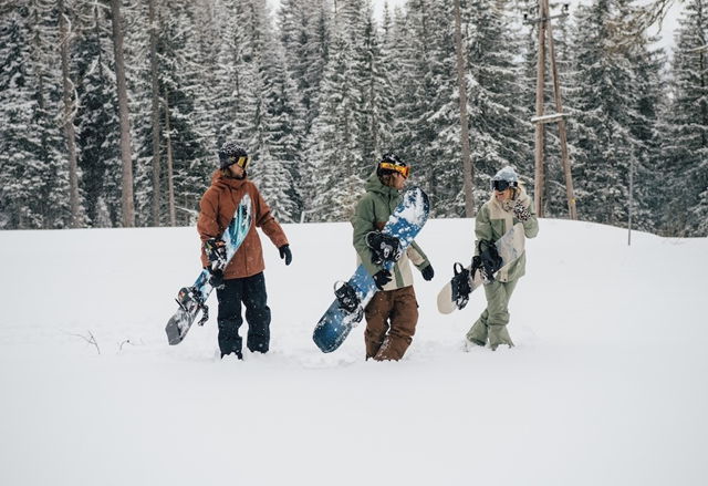 Menschen gehen mit Snowboard im Schnee